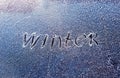 Text the word winter scraped on the frosty glass covered with white frost crystals on the car windshield on a winter cold clear Royalty Free Stock Photo