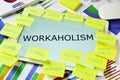 The text workaholism in a tablet on an office desk Royalty Free Stock Photo