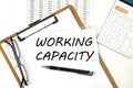 Text WORKING CAPACITY on the white paper on clipboard with chart and calculator Royalty Free Stock Photo