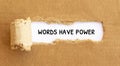 Text Worlds Have Power appearing behind torn brown paper