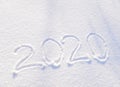 2020 text written on the background of fresh snow texture - winter holiday, Merry Christmas, New Year concept Sunny day Royalty Free Stock Photo
