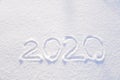 2020 text written on the background of fresh snow texture - winter holiday, Merry Christmas, New Year concept Sunny day Royalty Free Stock Photo