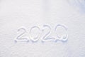 2020 text written on the background of fresh snow texture - winter holiday, Merry Christmas, New Year concept Sunny day Royalty Free Stock Photo