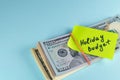 Text written note Holiday budget, dollars cash money in rubber band with note, on copy space background - concept of financial Royalty Free Stock Photo