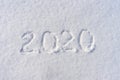 Text 2020 written on white fresh snow in sunny winter day. Merry Christmas and Happy New Year. Winter holiday concept Royalty Free Stock Photo