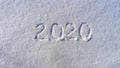 Text 2020 written on white fresh snow in sunny winter day. Merry Christmas and Happy New Year. Winter holiday concept Royalty Free Stock Photo