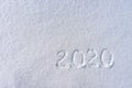 Text 2020 written on white fresh snow in sunny winter day. Merry Christmas and Happy New Year. Winter holiday concept Royalty Free Stock Photo