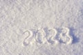 Text 2023 written on white fresh sparkling snow on sunny winter day. Merry Christmas and Happy New Year. Winter holiday concept. Royalty Free Stock Photo