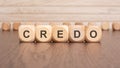 the text 'credo' is written on wooden cubes on a brown background