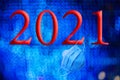 Text with the year number 2021 with a background of out-of-focus bright blue lights with Bokeh effect