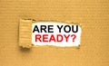 The text Are You Ready appearing behind torn brown paper Royalty Free Stock Photo