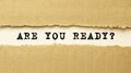 Text ARE YOU READY appearing behind torn brown paper. Top view Royalty Free Stock Photo