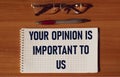 Text Your opinion is important to us, written on notepad and wooden table Royalty Free Stock Photo