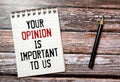 Text Your opinion is important to us, written on notepad and wooden table Royalty Free Stock Photo