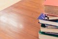 Textbook stack on wood table with blur background in university library with copy space. Photo concept of education knowledge and