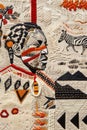 Textile artwork featuring a Namibian warrior adorned with traditional patterns and intricate embroidery