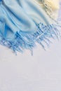 Textile background with the texture of a knitted scarf stole blue creamy yellow fabric with a fringe with a color gradient in