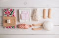 Textile doll in the sewing process with accessories and materials: fabric, thread, needle on white wooden background Royalty Free Stock Photo