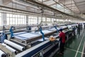 textile factory with workers operating machinery, producing high-quality textiles