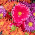 Textile fake red, orange and mauve dahlia flowers top view close up. Royalty Free Stock Photo