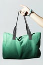 Textile handbag in woman hand. fashion green sport bag