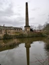 Textile mill stone chimney stood on pedestal base with reflections Royalty Free Stock Photo