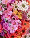 Textile orange, pink and pale white fake flowers top view close up. Royalty Free Stock Photo