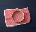 Textile red napkin and a round sieve for flour, blue wooden background
