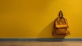 A textile teenage school backpack hangs on a yellow wall. Banner, a place for text. Generative ai.