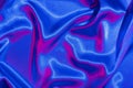 Textiles folds in neon blue-pink light. Trendy colors and shiny abstract background Royalty Free Stock Photo