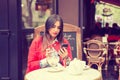 Texting. indian, asian woman sitting at outdoor cafe using cellphone. People and technology Royalty Free Stock Photo