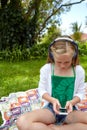 Texting while listening to her favorite songs. a young girl listening to music on her cellphone while sitting outside. Royalty Free Stock Photo