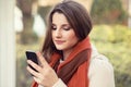 Texting, reading sms. Closeup portrait head shot beautiful young woman girl student looking on mobile phone looking isolated city Royalty Free Stock Photo