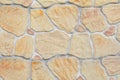 Texture of an artificial stone wall. Beige stones in cement. Decorative fence imitating masonry Royalty Free Stock Photo
