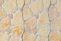Texture of an artificial stone wall. Beige stones in cement. Decorative fence imitating masonry Royalty Free Stock Photo
