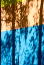 Texture, background, pattern. The wall of the building is painted with bright colors, a game of shadows from trees Royalty Free Stock Photo