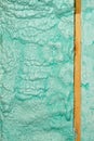 Texture and background of a wall made of ecological construction foam in a light green color near a wooden beam Royalty Free Stock Photo