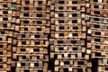 Texture and background for wallpaper from wooden beams and sticks - pallets stacked in piles and standing by the wall. Platforms