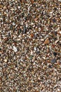 The texture of the beach with coarse sand. The texture of the pebble beach. Background of small pebbles on the beach. Wet pebbles Royalty Free Stock Photo