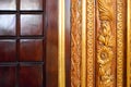 Texture of a beautiful carved wooden lacquered two-tone surface with patterns of squares, plant twigs and flowers. The background.