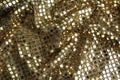 Texture of beautiful golden fabric with paillettes as background