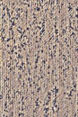 Texture of a beige mat with black spots fabric. Background of beige carpet with brown abstract spots