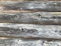 Texture of a black gray old wood wall made of logs, a fence of horizontal worn-out burnt, rotten boards with cracks and knots Royalty Free Stock Photo
