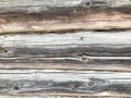 Texture of a black gray old wood wall made of logs, a fence of horizontal worn-out burnt, rotten boards with cracks and knots