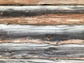 Texture of a black gray old wood wall made of logs, a fence of horizontal worn-out burnt, rotten boards with cracks and knots Royalty Free Stock Photo