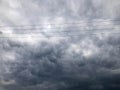 Texture black tensioned high-voltage wires for electricity against a background of dark blue sullen storm stormy sky rain clouds Royalty Free Stock Photo