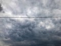 Texture of black tensioned high-voltage wires for electricity against a background of dark blue sullen stormy sky with rain clouds Royalty Free Stock Photo