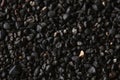 Texture of black volcanic sand for background. Black Sand beach macro photography. Close-up view of volcanic sand Royalty Free Stock Photo