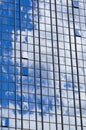 Texture of blue shiny glass skyscraper windows, buildings with reflection of white clouds and sky. The background Royalty Free Stock Photo