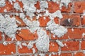 Texture of a brick red wall. On wall are pieces of cement